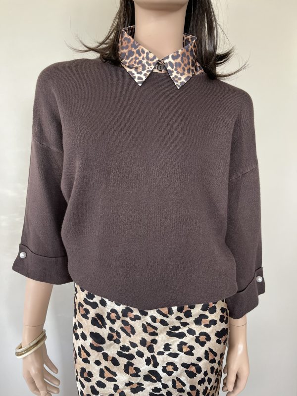 Trui in de kleur choco met ronde hals en driekwart mouwen. Als detail zit er een parel op de onderkant van de mouwen.