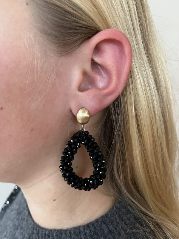Zwarte oorsteker oorbellen in luxe druppelvorm met goudkleurig detail.