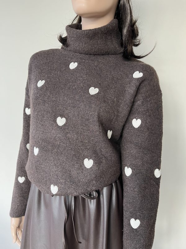 Donkerbruine coltrui met witte hartjes. Gemaakt van een zachte stof die comfortabel aanvoelt.
