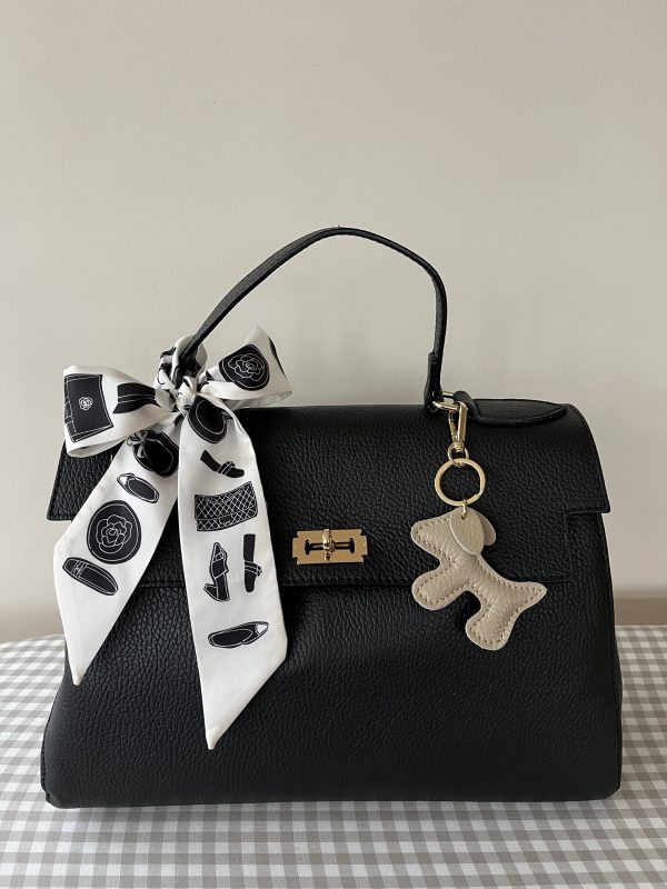 Stijlvolle en tijdloze zwarte hoogwaardig echt leren tas met gouden details.