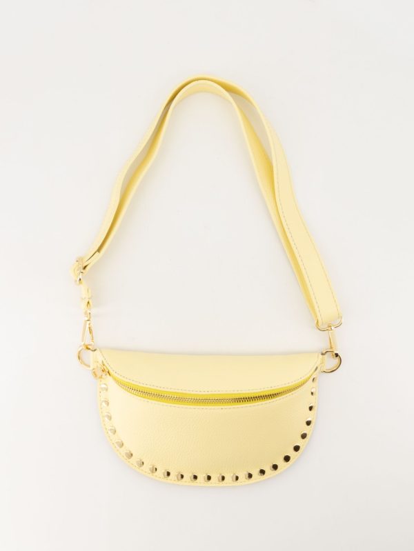 Hoogwaardig echt leren heuptas die ook als crossbody tas gedragen kan worden. De tas is afgewerkt met studs en goudkleurige hardware. Kleur: geel.